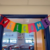 Rainbow Welcome sign hanging on classroom door.